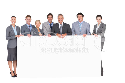 Smiling business team holding poster