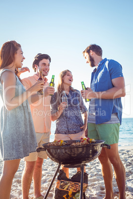 Happy friends doing barbecue and drinking beer