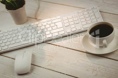 White keyboard and cup of coffee