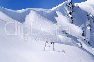 Old surface lift and mountains with snow cornice