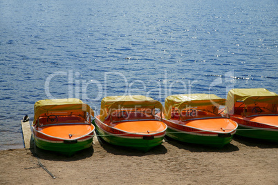Pedal boats in a row at the shore