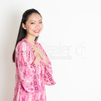 Asian female in pink batik dress
