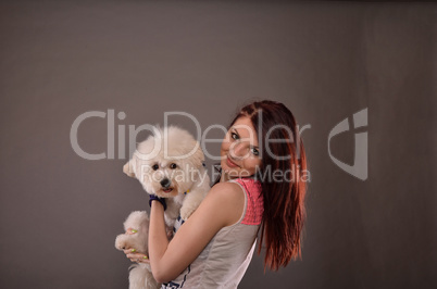 Teenage girl holding Maltese puppy