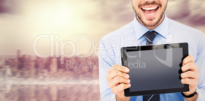 Composite image of happy businessman showing his tablet pc