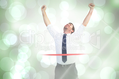 Composite image of businessman celebrating success with arms up