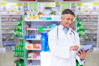 Composite image of happy doctor using tablet pc