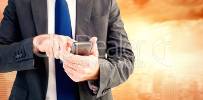 Composite image of businessman sending a text message