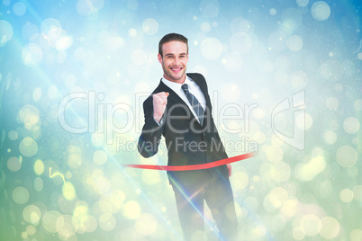 Composite image of happy businessman crossing the finish line