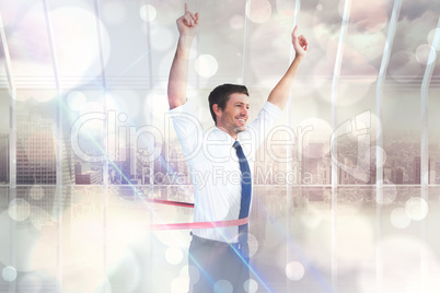 Composite image of businessman crossing the finish line