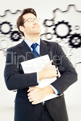 Composite image of handsome businessman holding his laptop