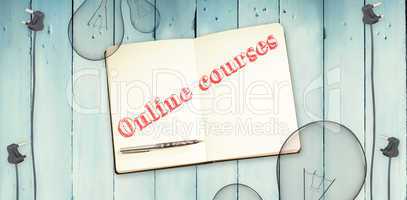 Online courses against notepad and bulbs on wooden background