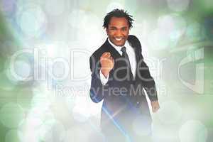 Composite image of happy businessman with fist