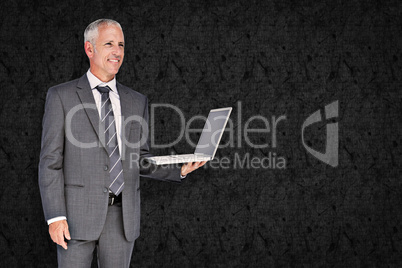 Composite image of businessman using laptop