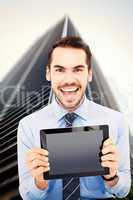 Composite image of happy businessman showing his tablet pc