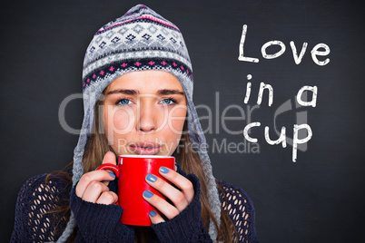 Composite image of beautiful woman in warm clothing drinking cof