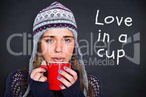 Composite image of beautiful woman in warm clothing drinking cof