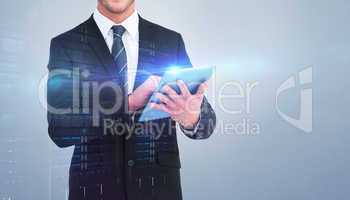 Composite image of happy businessman using his tablet pc