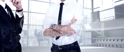 Composite image of smiling businessman with arms crossed