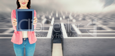 Composite image of elegant brunette using tablet