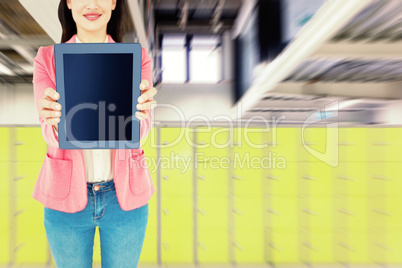 Composite image of elegant brunette using tablet