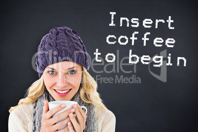Composite image of pretty blonde in winter fashion holding mug