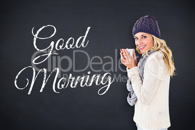 Composite image of pretty blonde in winter fashion holding mug