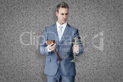 Composite image of businessman holding scales of justice