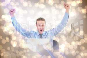 Composite image of cheering businessman at laptop