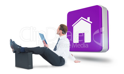 Composite image of businessman using tablet with feet up on brie