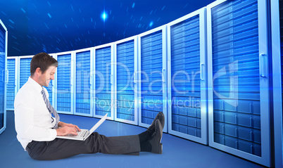 Composite image of businessman using laptop and smiling
