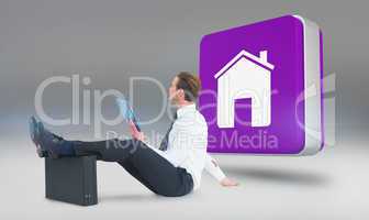 Composite image of businessman using tablet with feet up on brie