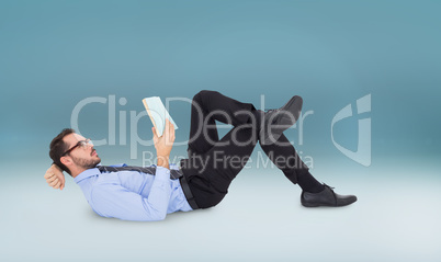 Composite image of businessman lying on the floor while reading