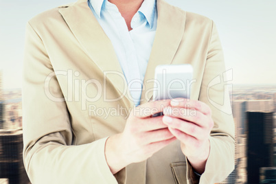 Composite image of businesswoman using her mobile phone