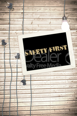Safety first against tablet and plugs on wooden background