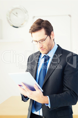 Composite image of businessman using a tablet computer