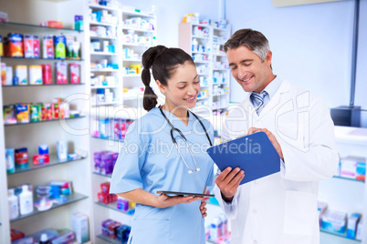 Composite image of doctor and nurse looking at clipboard