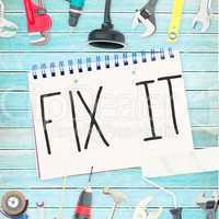 Fix it against tools and notepad on wooden background