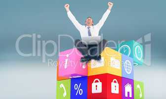 Composite image of businessman using laptop and cheering