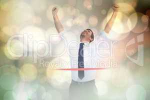 Composite image of businessman celebrating success with arms up