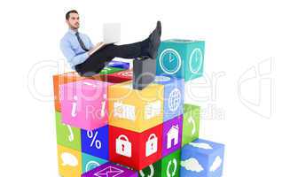 Composite image of businessman sitting on the floor with feet up