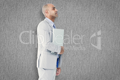 Composite image of businessman holding laptop