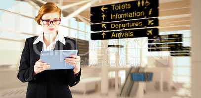 Composite image of redhead businesswoman using her tablet pc