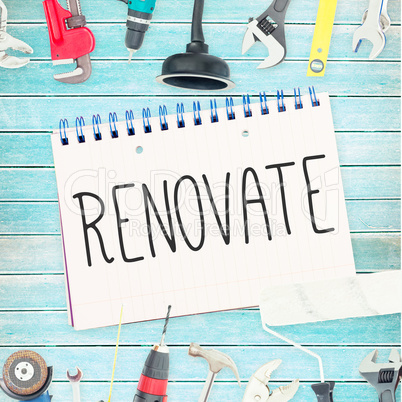 Renovate  against tools and notepad on wooden background