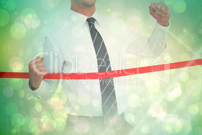 Composite image of businessman crossing the finish line