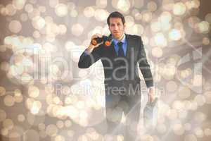 Composite image of serious businessman holding binoculars and a