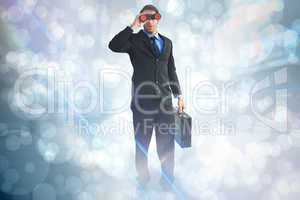 Composite image of businessman using binoculars while holding a