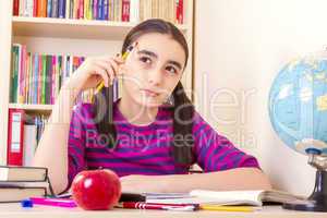 Little schoolgirl holding a pencil and thinking