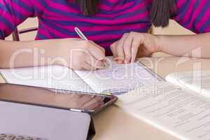 Schoolgirl doing her homework using digital tablet