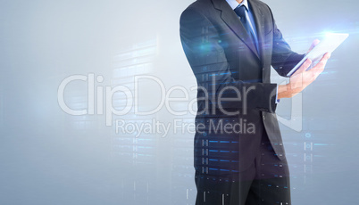 Composite image of businessman looking at the camera while using