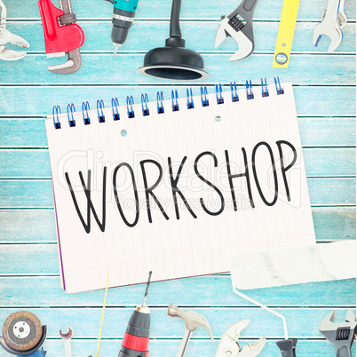 Workshop against tools and notepad on wooden background